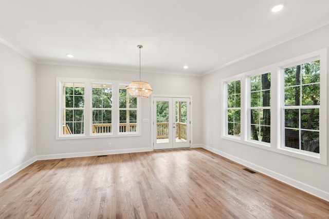 unfurnished dining area featuring a wealth of natural light, crown molding, and light wood-type flooring