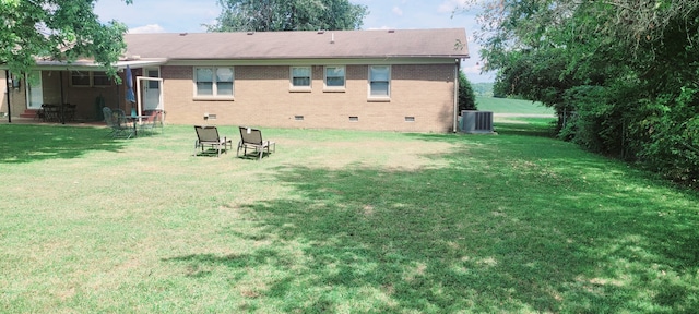 rear view of house featuring a lawn and cooling unit