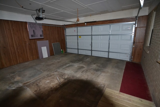 garage featuring a garage door opener and wooden walls