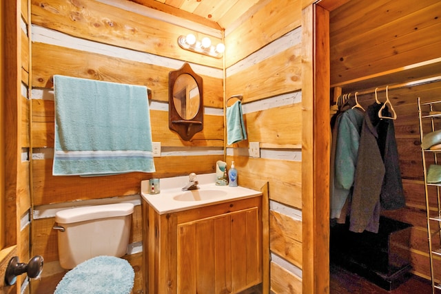 bathroom featuring vanity, wood walls, toilet, and wood ceiling