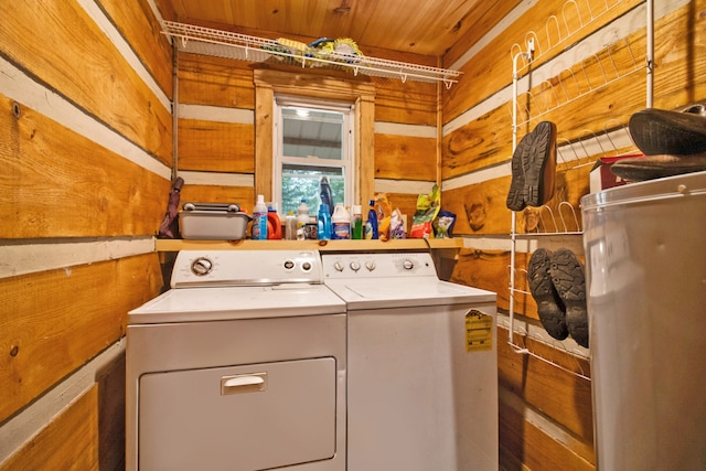 clothes washing area with wood ceiling, independent washer and dryer, wooden walls, and water heater