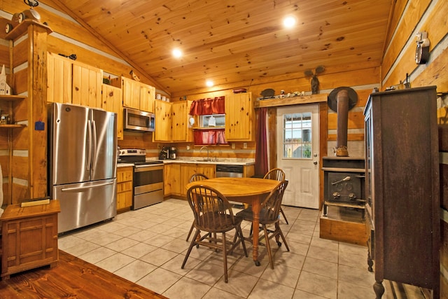 kitchen featuring light tile patterned flooring, stainless steel appliances, vaulted ceiling, and sink