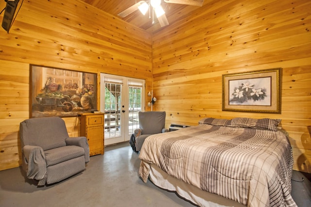 bedroom with access to exterior, french doors, high vaulted ceiling, concrete floors, and wooden walls