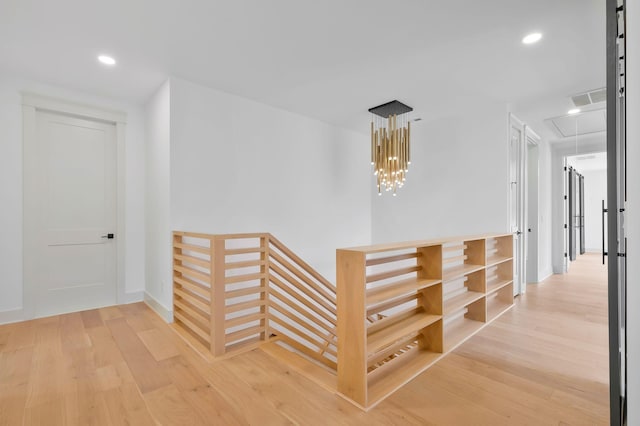 hall with attic access, recessed lighting, an upstairs landing, and wood finished floors