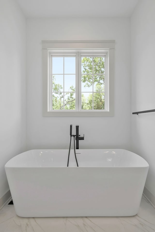 bathroom with tile patterned flooring and a bath