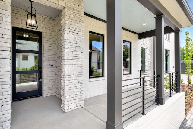 property entrance featuring a porch and brick siding