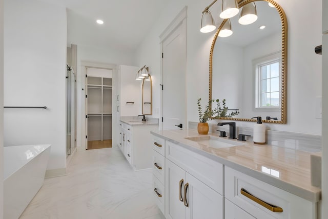 bathroom featuring tile patterned floors, a bathing tub, and vanity