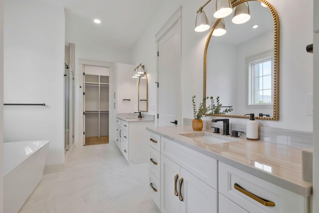 full bathroom with two vanities, a sink, marble finish floor, a stall shower, and a walk in closet