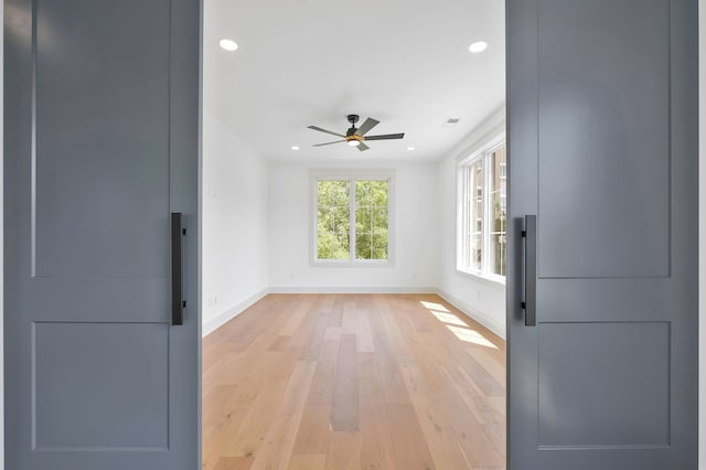 empty room with ceiling fan and light wood-type flooring