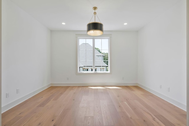 empty room with light wood finished floors, baseboards, and recessed lighting