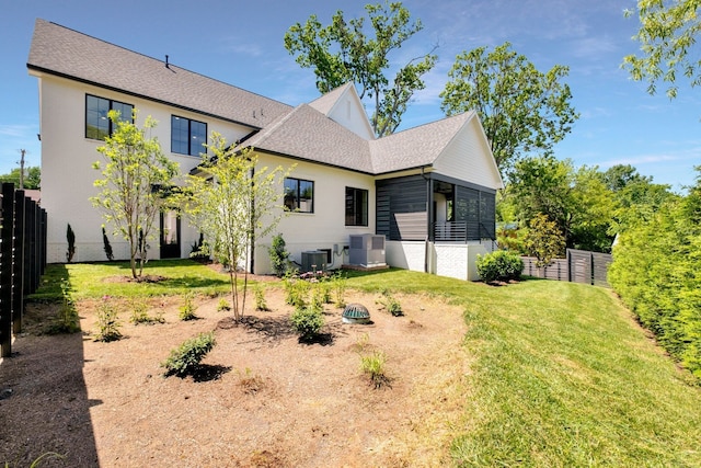 back of house featuring a yard and cooling unit