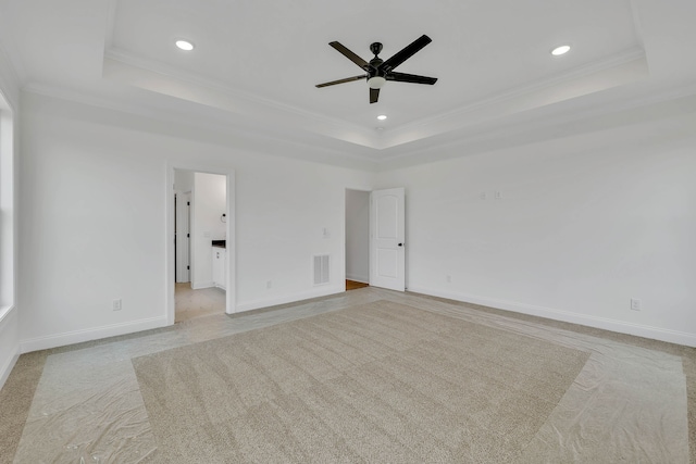 carpeted empty room with ceiling fan, crown molding, and a tray ceiling