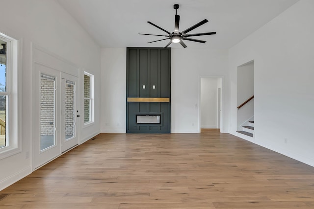 unfurnished living room featuring light wood-type flooring, plenty of natural light, and ceiling fan