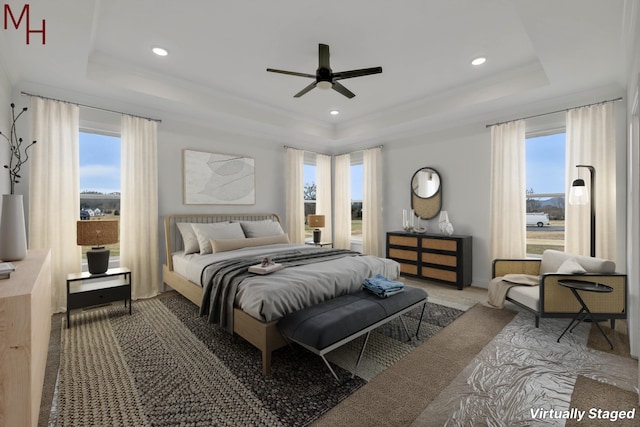 bedroom with ceiling fan, carpet floors, ornamental molding, and a tray ceiling