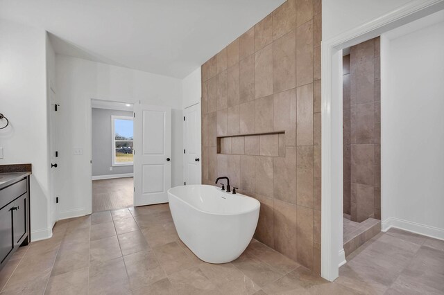 bathroom featuring tile patterned flooring, vanity, tile walls, and shower with separate bathtub