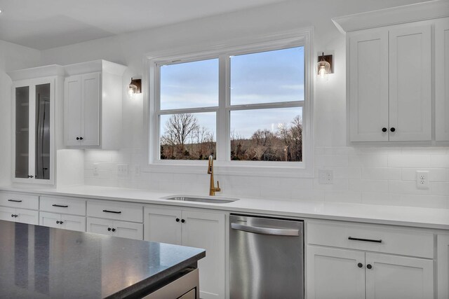 kitchen featuring backsplash, dishwasher, sink, and white cabinets