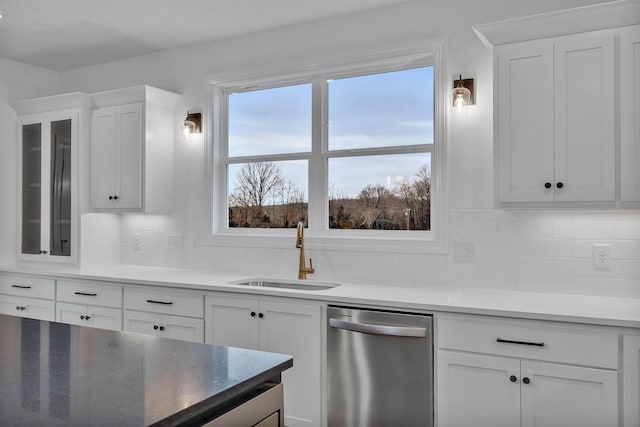 kitchen with a sink, decorative backsplash, dishwasher, glass insert cabinets, and white cabinetry