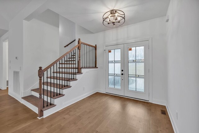 entryway featuring a chandelier, french doors, and light hardwood / wood-style flooring