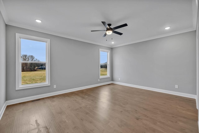 spare room with ornamental molding, baseboards, and wood finished floors