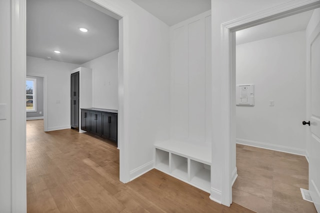 mudroom featuring recessed lighting, light wood-style flooring, and baseboards