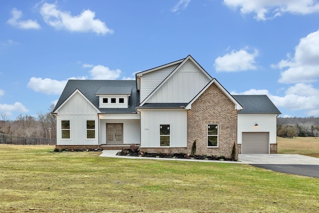 modern farmhouse featuring a front yard, an attached garage, and board and batten siding