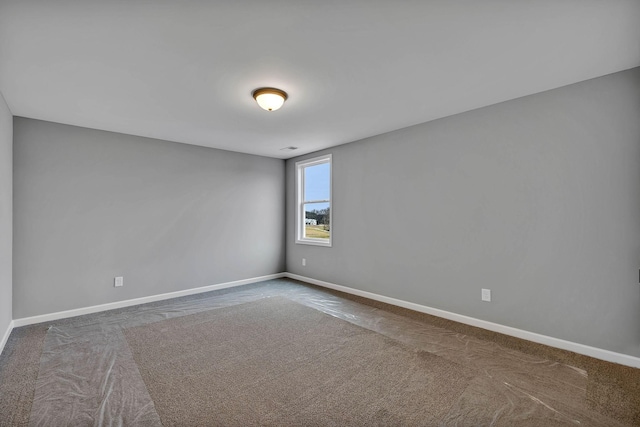 unfurnished room with baseboards and carpet floors