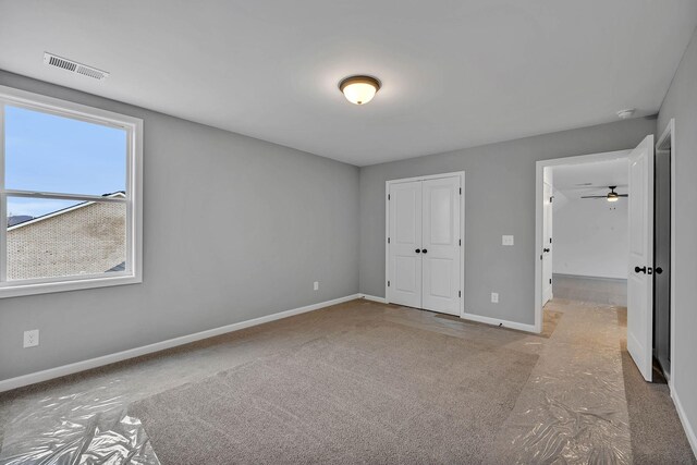 unfurnished bedroom with light carpet and a closet