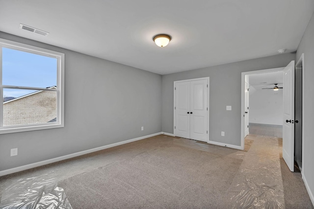 unfurnished bedroom featuring baseboards, visible vents, and a closet