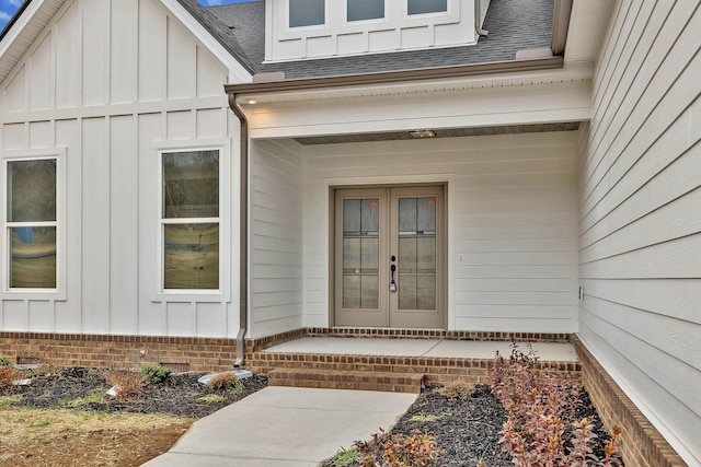 doorway to property featuring french doors, board and batten siding, and a shingled roof