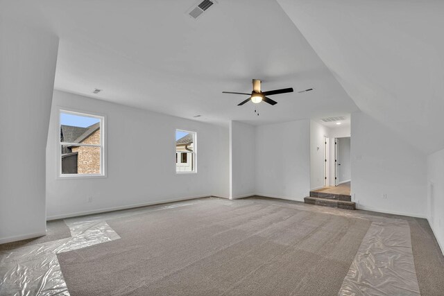 unfurnished living room with carpet, vaulted ceiling, and ceiling fan