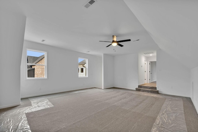 unfurnished living room with visible vents, baseboards, carpet, and ceiling fan