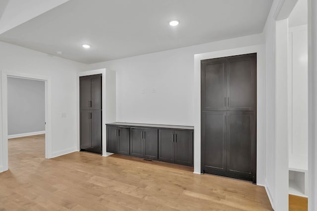 spare room featuring recessed lighting, baseboards, and light wood finished floors