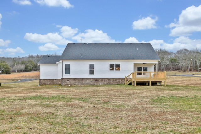 rear view of property with crawl space, a yard, a wooden deck, and roof with shingles