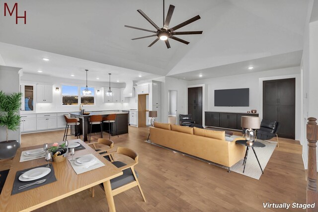 living area with light wood finished floors, recessed lighting, high vaulted ceiling, and a ceiling fan