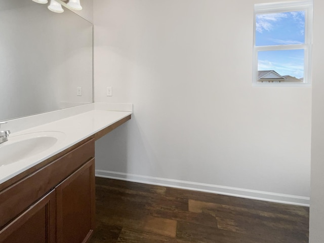 bathroom featuring baseboards, wood finished floors, and vanity