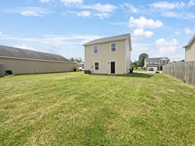 back of house featuring fence and a lawn