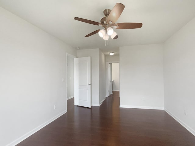 empty room with dark wood-style flooring, ceiling fan, and baseboards