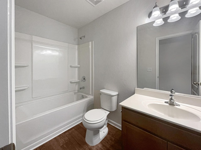 full bathroom with visible vents, shower / bathing tub combination, toilet, vanity, and wood finished floors