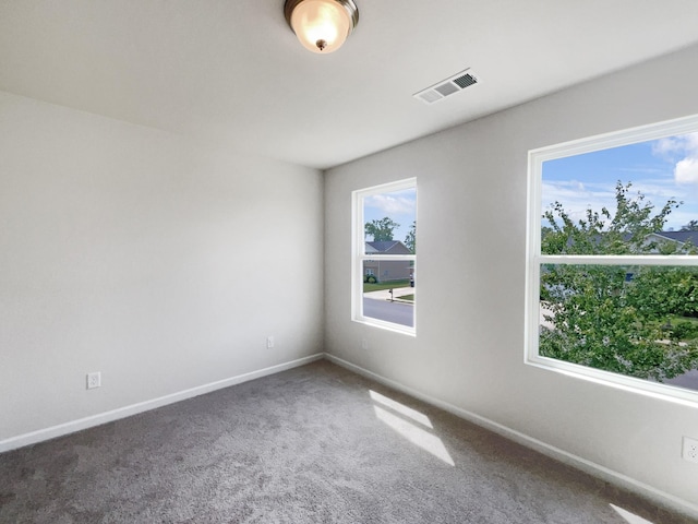 carpeted spare room with baseboards and visible vents