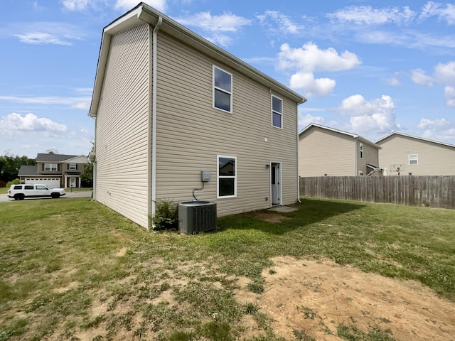 back of house with cooling unit, a yard, a residential view, and fence