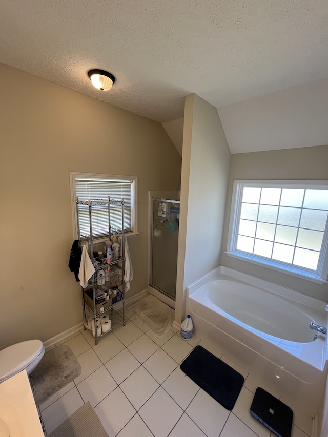 bathroom featuring tile patterned floors, vaulted ceiling, a textured ceiling, plus walk in shower, and toilet