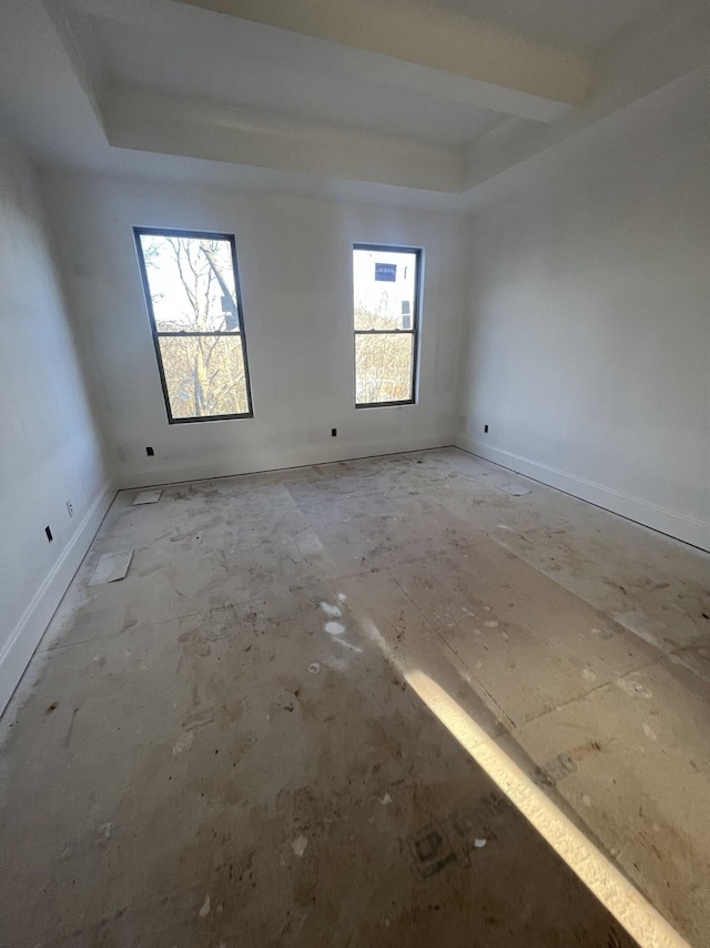 unfurnished room featuring a raised ceiling and baseboards