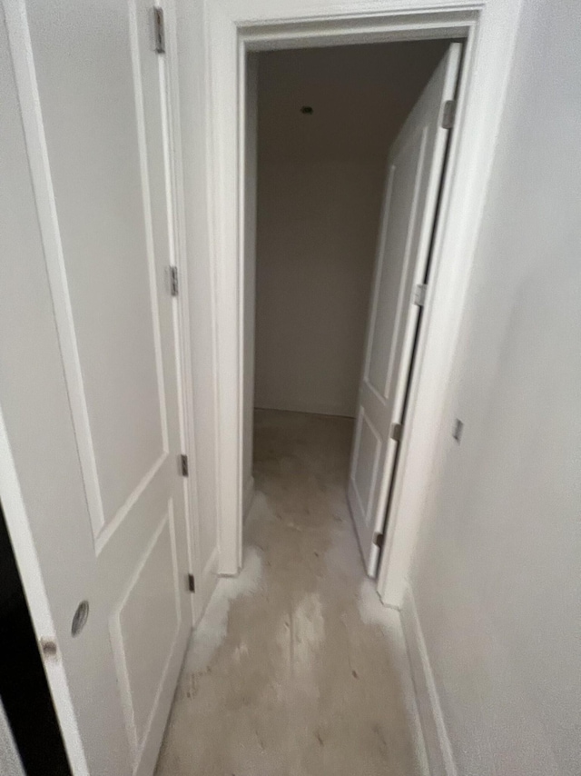 hallway with unfinished concrete flooring