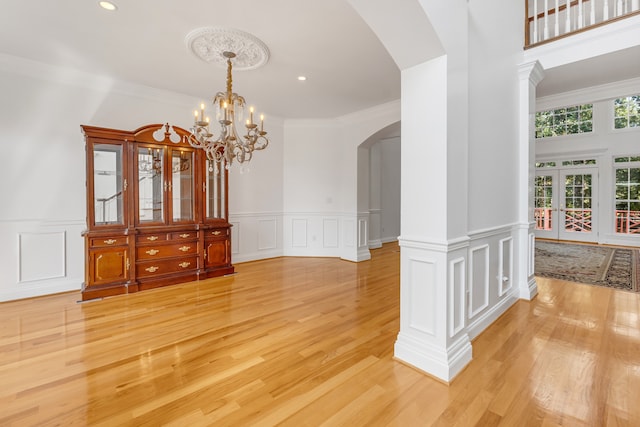 dining room with light hardwood / wood-style flooring, ornamental molding, and a notable chandelier