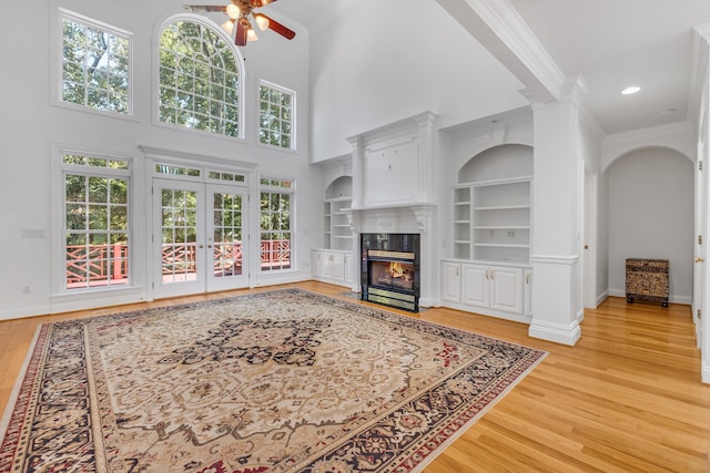 living room with ceiling fan, a fireplace, ornamental molding, and light hardwood / wood-style flooring