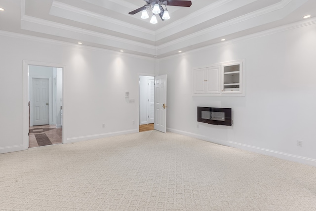 unfurnished living room featuring a tray ceiling, ceiling fan, crown molding, and light carpet