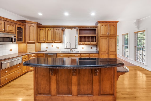 kitchen featuring appliances with stainless steel finishes, brown cabinets, a warming drawer, and a sink