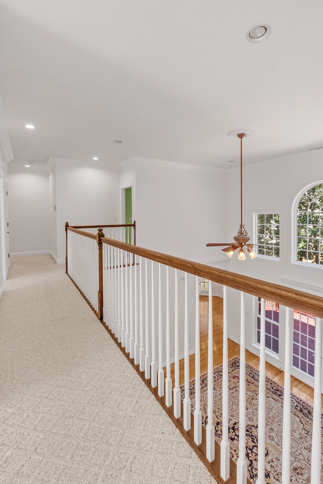 hall featuring baseboards, crown molding, and recessed lighting