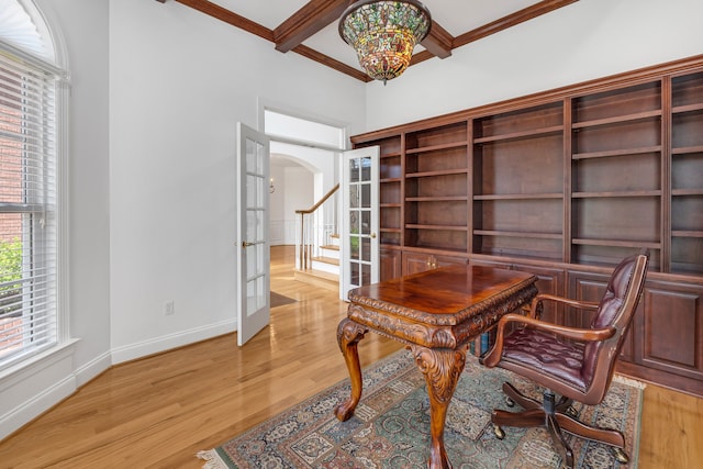 office area featuring arched walkways, baseboards, french doors, light wood finished floors, and beamed ceiling