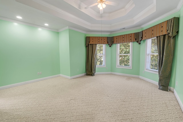 unfurnished room with ornamental molding, a raised ceiling, light carpet, and baseboards